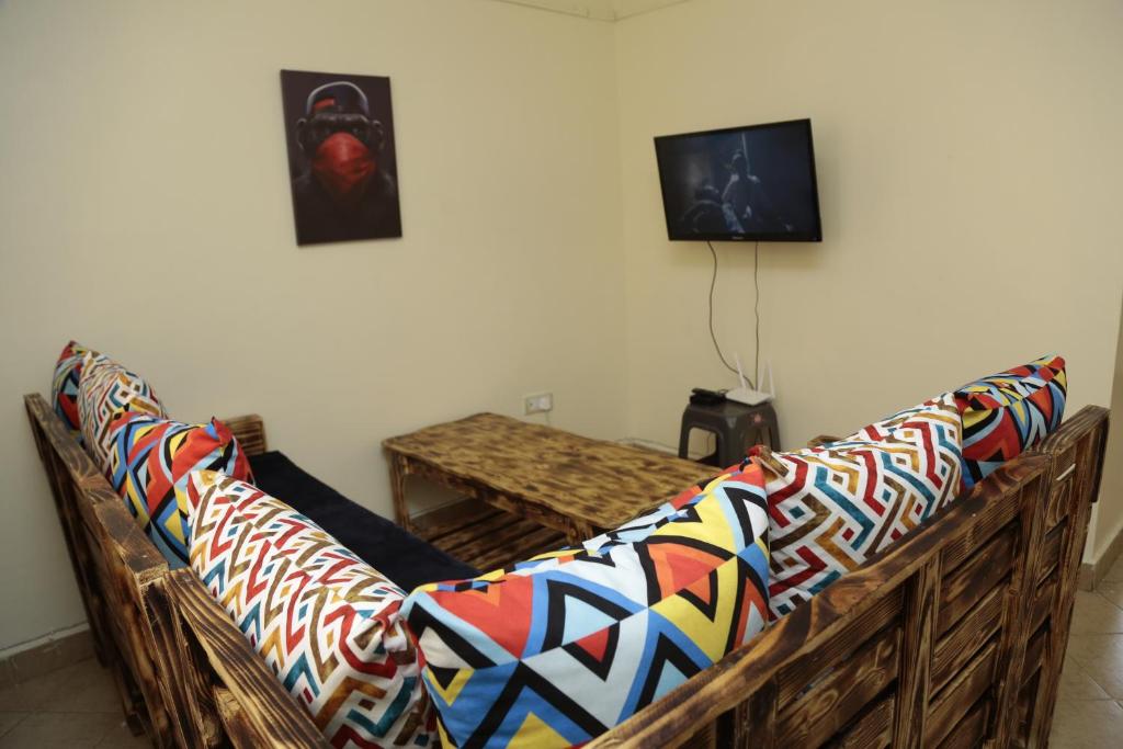 a couch with colorful pillows in a living room at Rooftop Haven Allsoaps in Nairobi