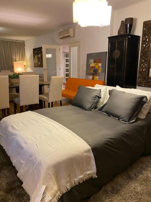 a large bed in a room with a dining room at Luxury Family suite for 4 in Caxias