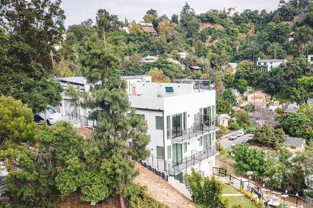 Luxury retreat with rooftop, hot tub & views في لوس أنجلوس: منزل أبيض على تلة فيها أشجار