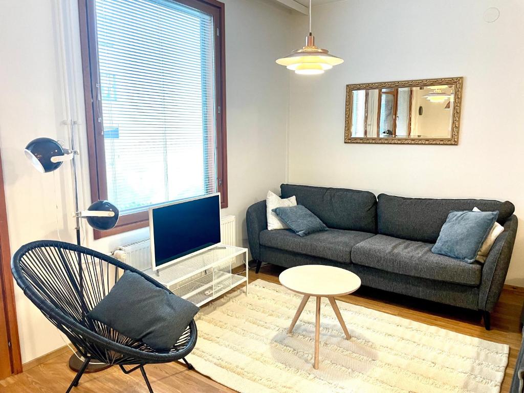 a living room with a couch and a chair at Seaside Apartment in Helsinki