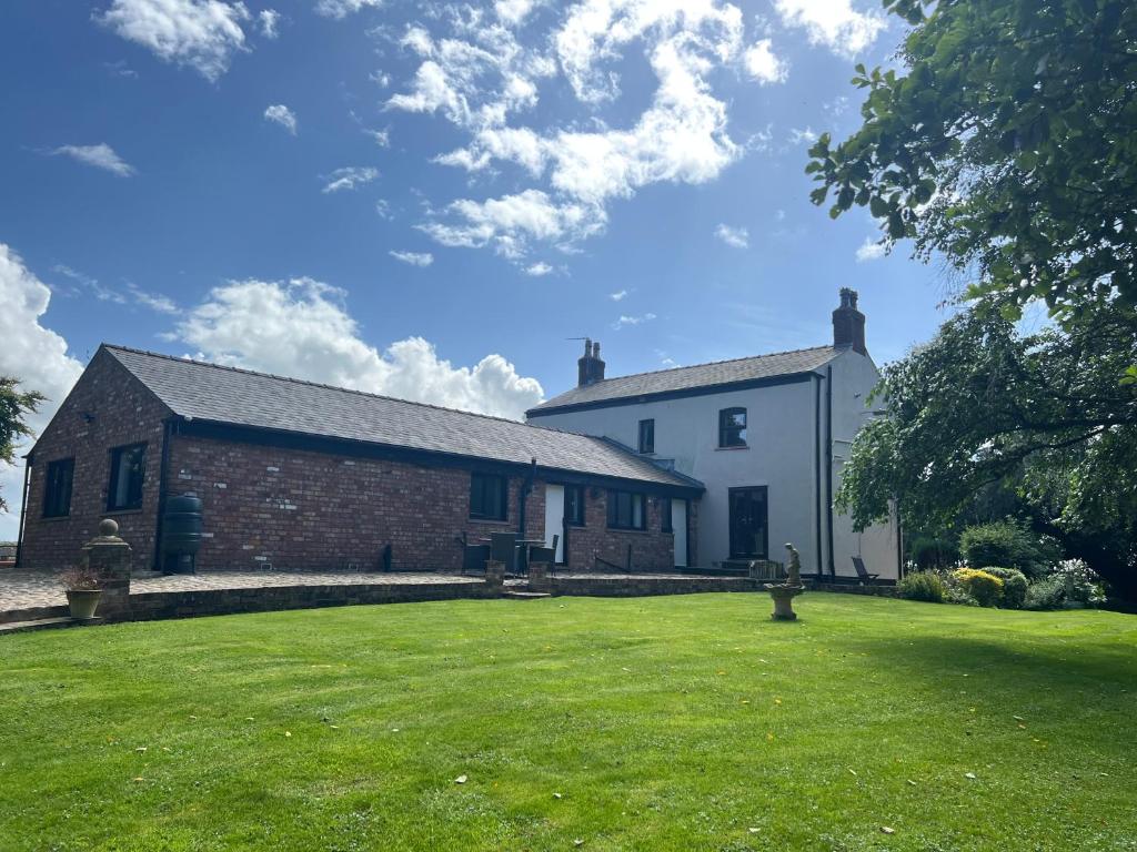 a house with a grassy yard in front of it at Rural Family Farmhouse with Countryside views in Southport