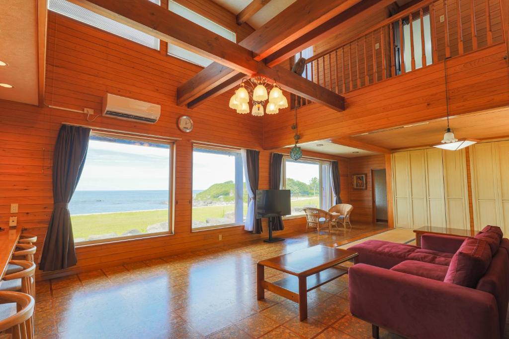 sala de estar con sofá y TV en オーシャンビュー　秋田の夕日・海の見える別荘セントキルダ　一棟貸し, en Nikaho