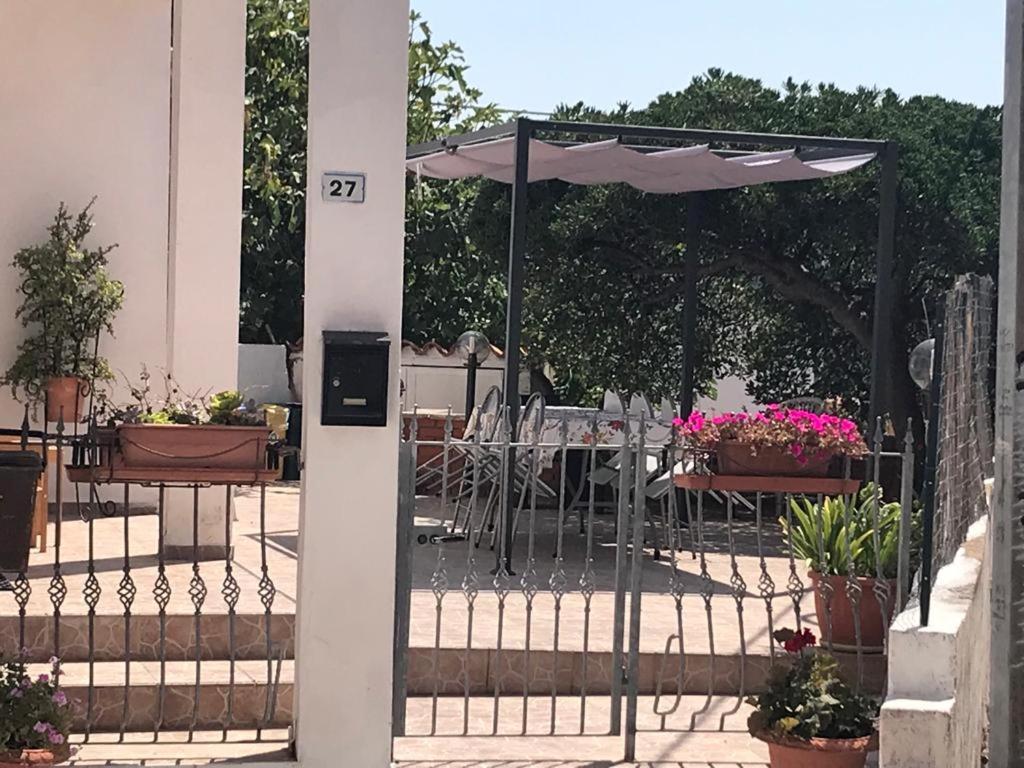 eine Terrasse mit einem Sonnenschirm, Tischen und Stühlen in der Unterkunft La casa dei nonni in Talavà