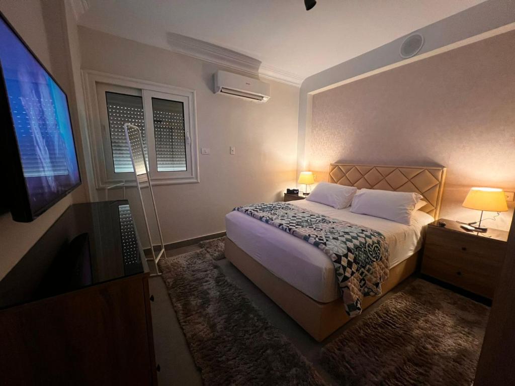 a bedroom with a bed and a flat screen tv at Egypt in Cairo