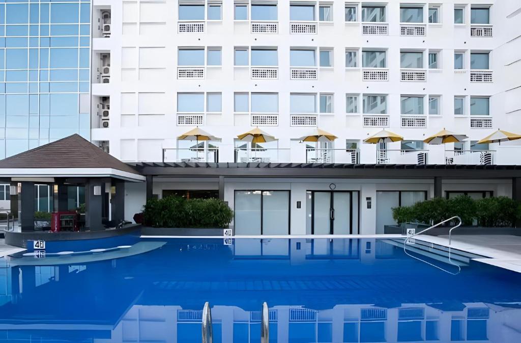 a hotel with a swimming pool in front of a building at 2 Bedroom Condo in Cebu - opp Ayala in Cebu City