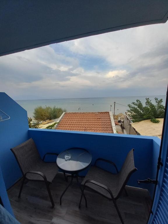 un tavolo e sedie su un balcone con vista sull'oceano di Bis Studios ad Alikanás