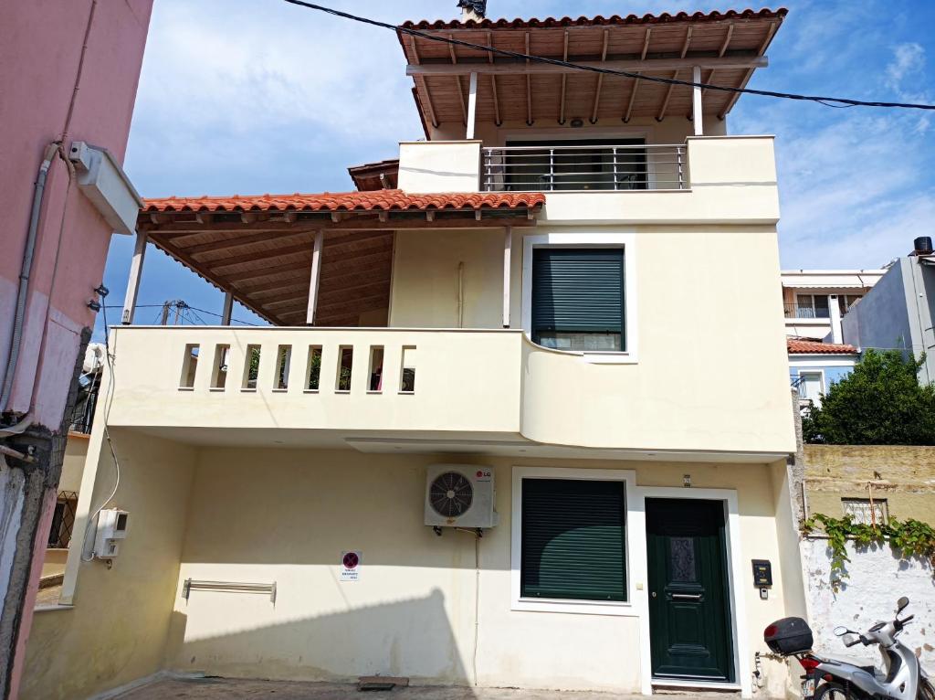 a white house with a balcony on top of it at studio apartment KAMARES in Mytilini