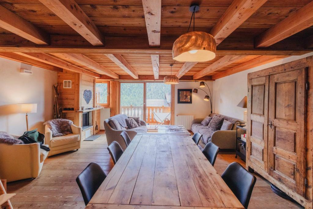 a large wooden table in a living room with a couch at Appartement en résidence standing, ski aux pieds et garage in Montgenèvre