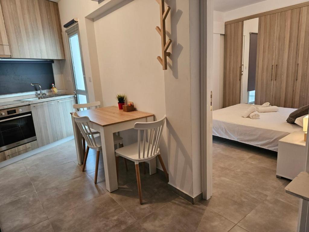 Il comprend une cuisine et un salon avec une table et des chaises. dans l'établissement SC_apartments, à Kato Pyrgos