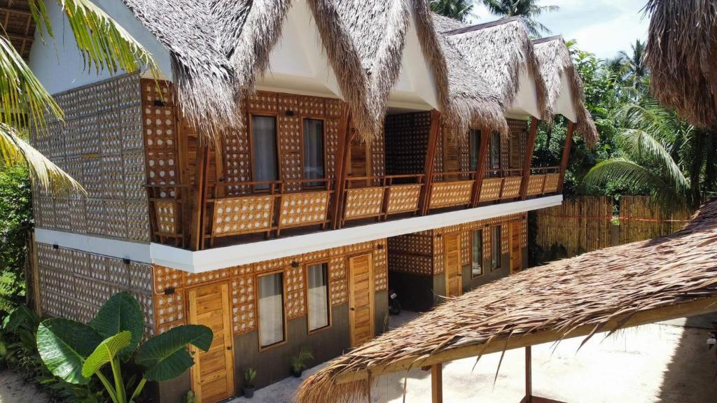 un edificio con portico in legno e balcone di M-Resort Siargao a General Luna