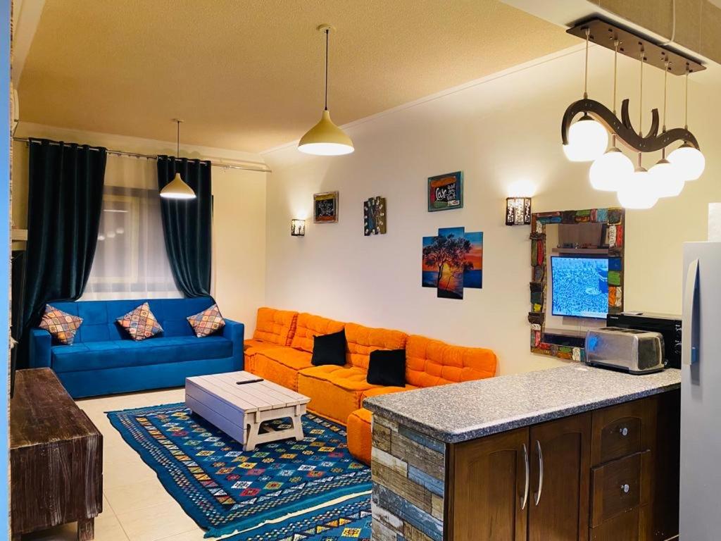 拉斯蘇德爾的住宿－Furnished Chalet Apartment at La Hacienda Ras Sedr，客厅配有橙色家具和蓝色沙发
