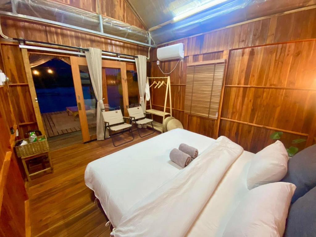 a bedroom with a white bed in a room with wooden walls at m&r house 