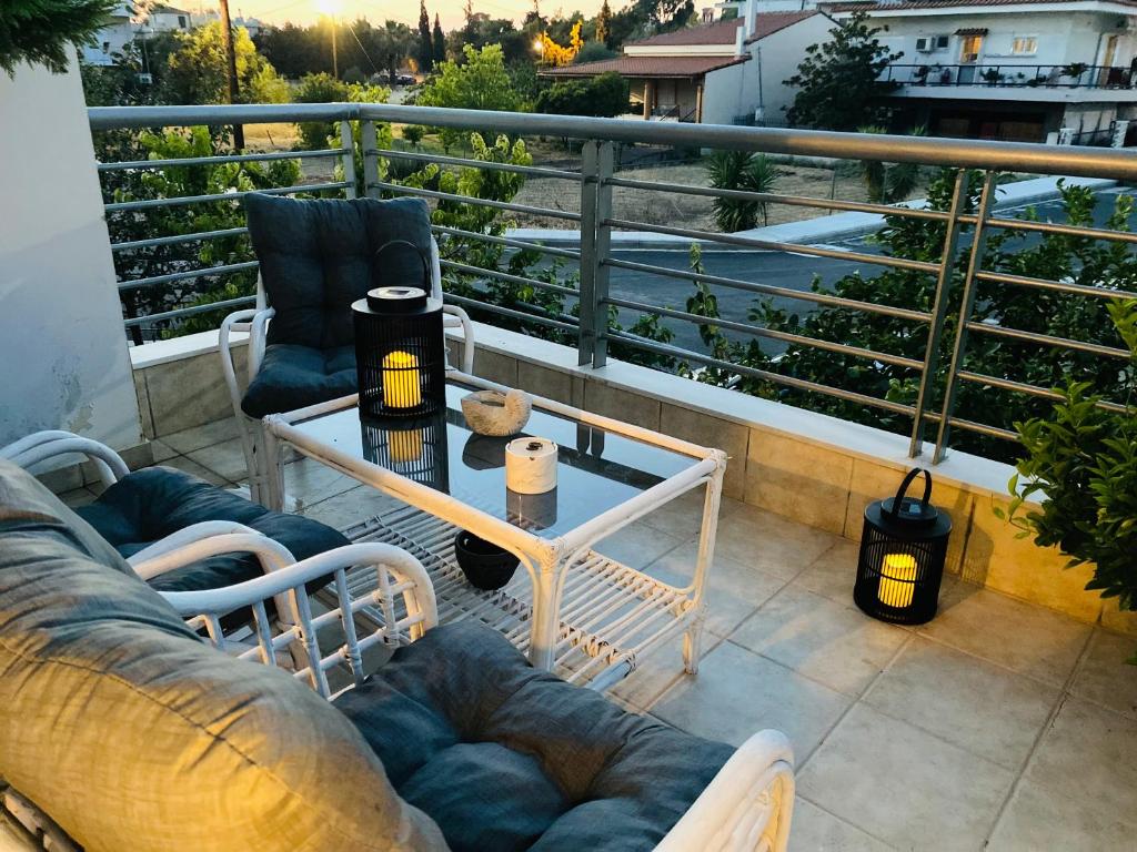 a balcony with a couch and a table on a balcony at Homey Family ArtAki in Néa Artáki