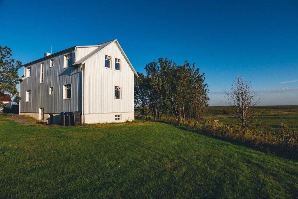 een groot wit huis op een groen veld bij Farmhouse Meiri-Tunga 1 in Hella