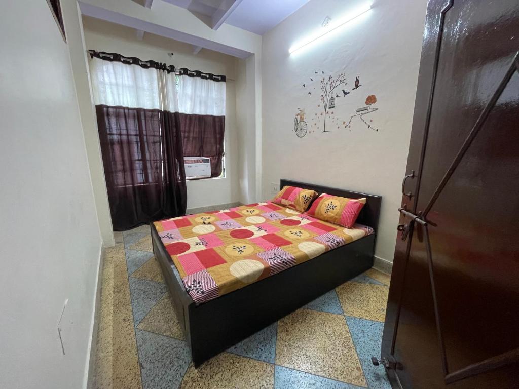 um pequeno quarto com uma cama num quarto em Rukmani Home Stay em Mathura