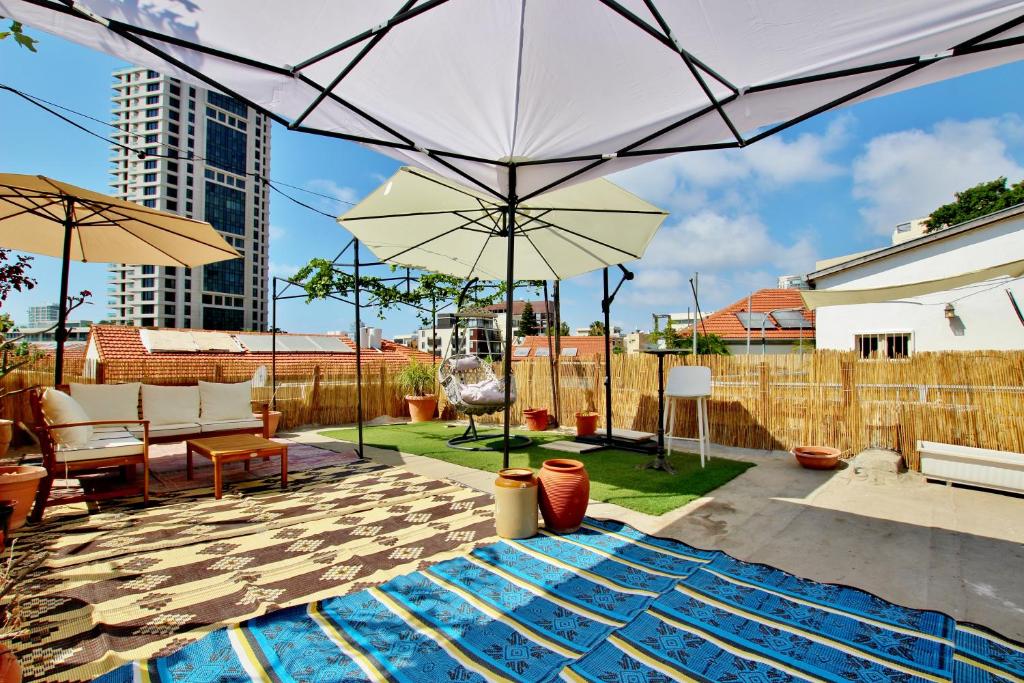a backyard with a swimming pool and an umbrella at The house at shabazi neve tzedek in Tel Aviv