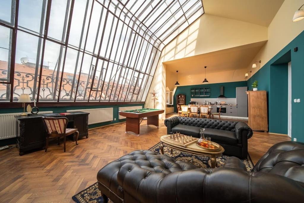 een woonkamer met lederen meubels en een groot raam bij Chateau Charme - Prague centre in Praag