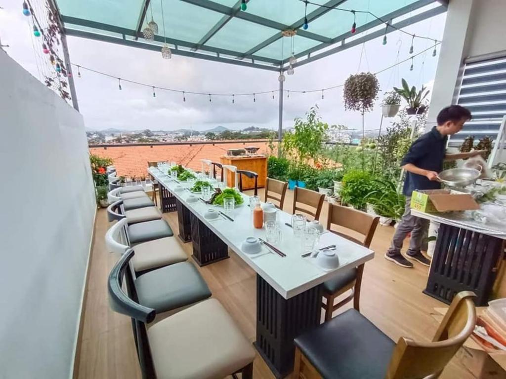 une salle à manger avec une longue table et des chaises dans l'établissement WHITE COFFEE HOUSE HOTEL, à Đà Lạt