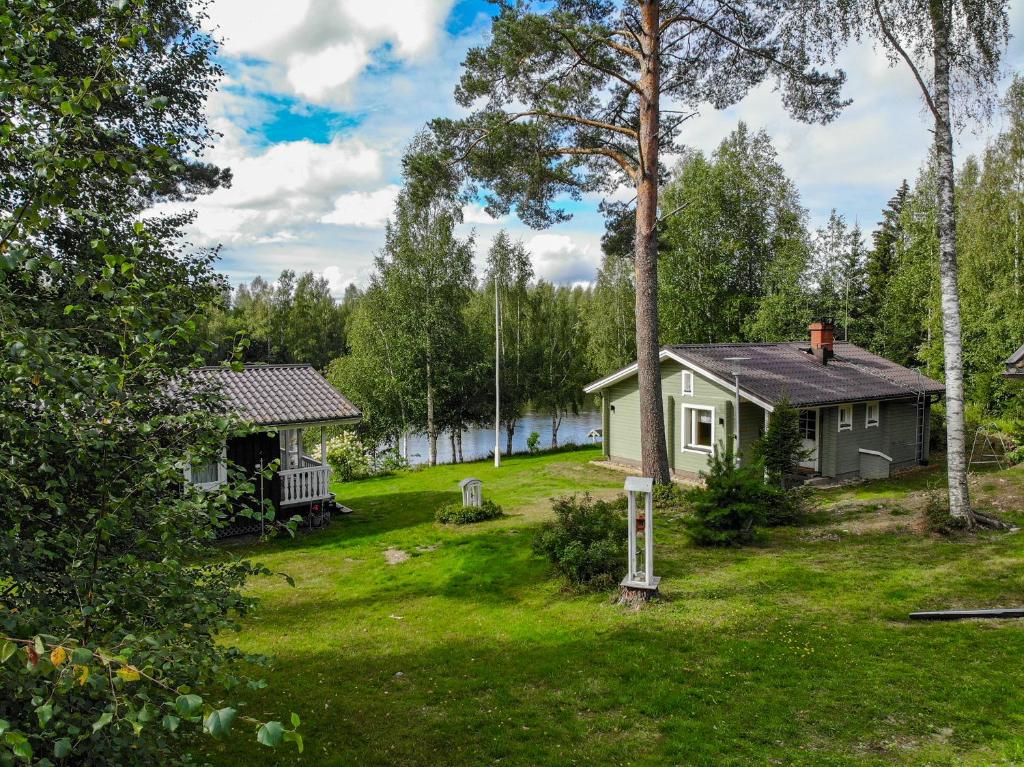 une petite maison dans une cour à côté d'un lac dans l'établissement Villa Kastehelmi, à Suonenjoki