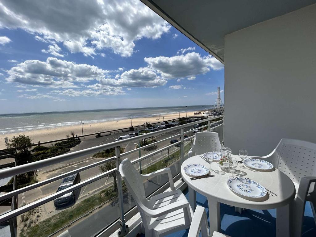 un balcon avec une table et des chaises et une vue sur la plage dans l'établissement Appartement 3 pièces, 6 couchages, balcon, parking, proche mer - FR-1-224C-263, à Saint-Jean-de-Monts