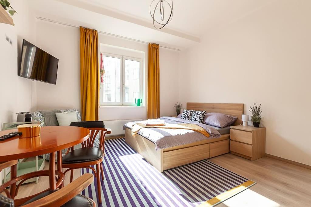 um quarto com uma cama, uma mesa e uma sala de jantar em Renovated Cosy & Quiet flat near Smichov Station em Praga
