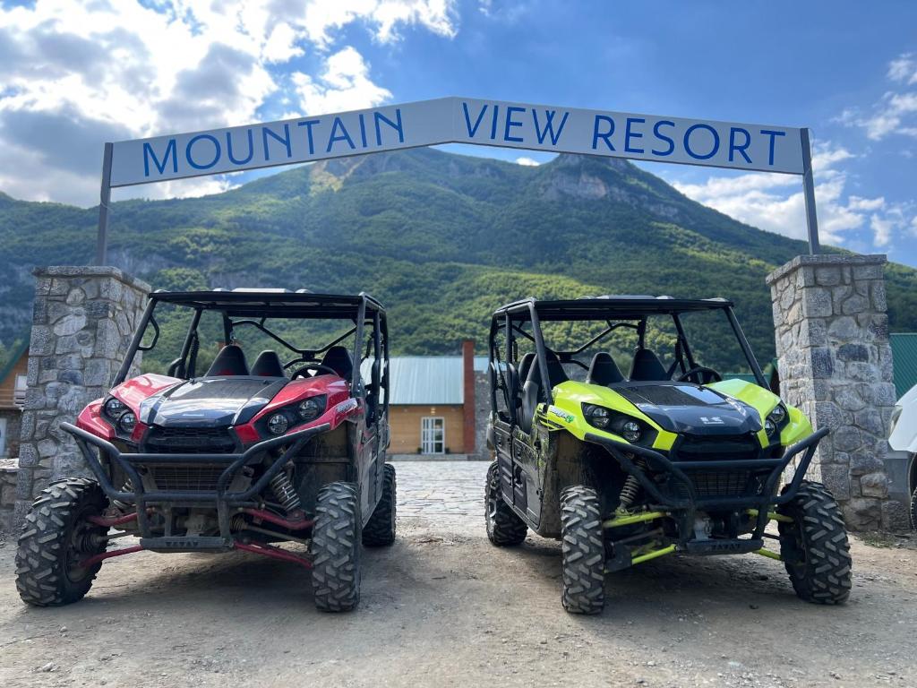 two atvs parked under a mountain view resort sign at Mountain View Resort in Gusinje