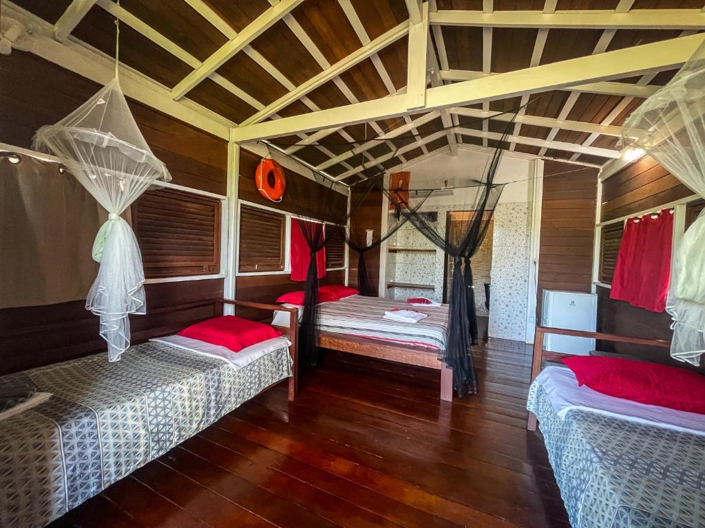 Duas camas num quarto com pisos e tectos em madeira em Pousada Vettore em Atins
