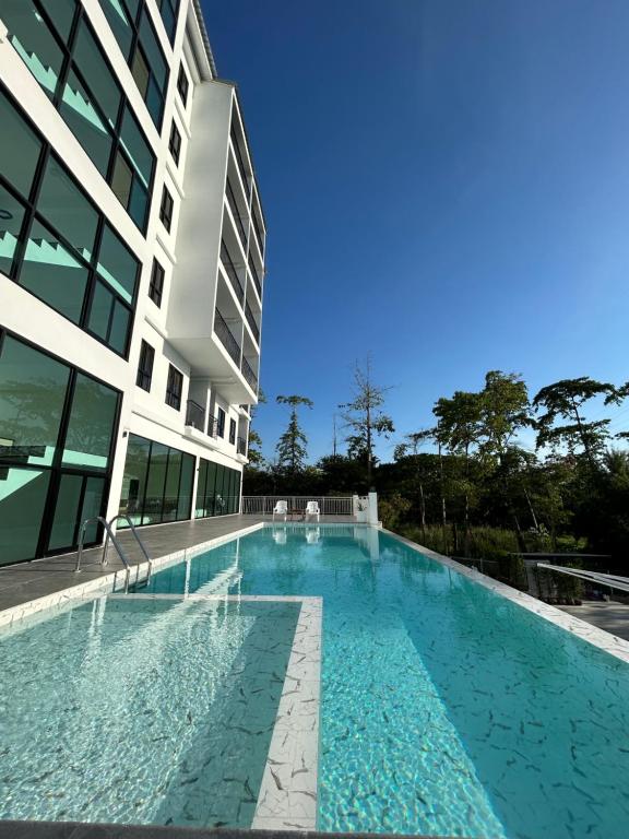 una gran piscina junto a un edificio en GEEN Hotel Chonburi, en Chonburi