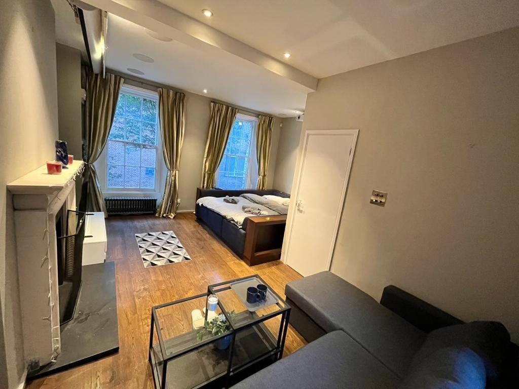 - un salon avec un canapé et un lit dans l'établissement 4 floor Apartment in Covent Garden, à Londres
