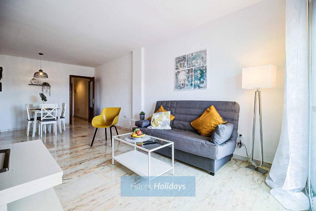 a living room with a blue couch and a table at HH Pueblo Butterfly in Benalmádena