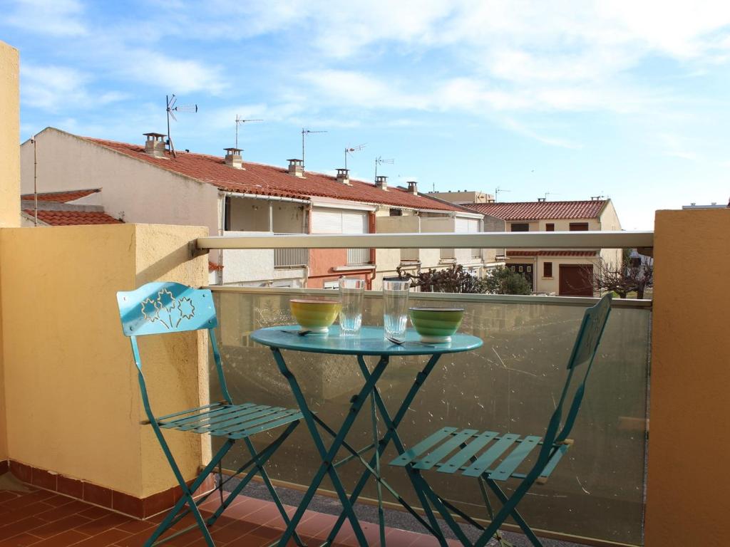 une table avec deux chaises et des verres sur un balcon dans l'établissement Appartement traversant avec balcons, parking privé, à 250m de la plage - Port-la-Nouvelle - FR-1-229C-55, à Port-la-Nouvelle