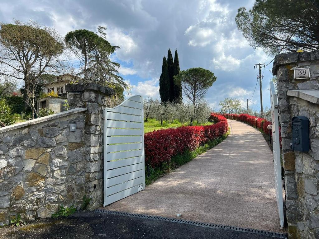 un portail blanc et un mur en pierre à côté d'une allée. dans l'établissement Da Piero e Paola, à Arezzo