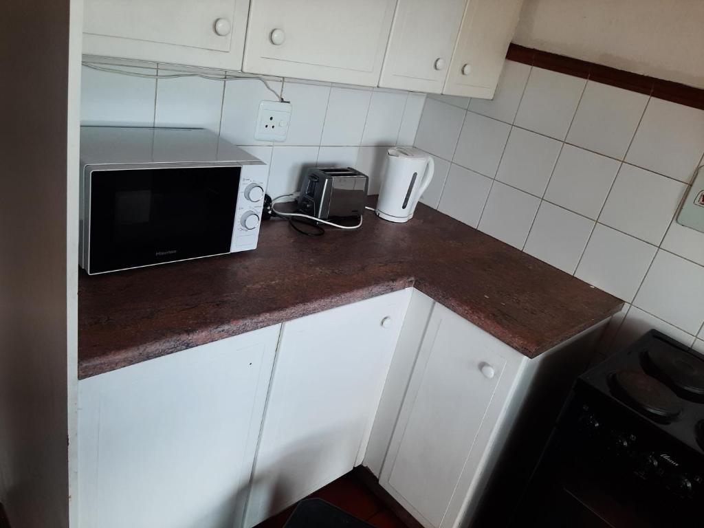- une cuisine avec un comptoir et un four micro-ondes dans l'établissement 3 Bedroom Manor Gardens House, à Durban