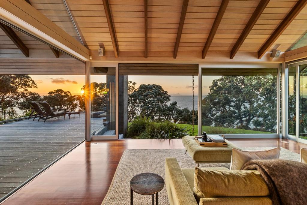 an open living room with a view of the ocean at The Glasshouse in Whangarei Heads