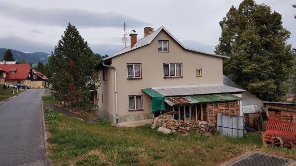 a large white house with a green awning on a street at Apartmany Dolni Rokytnice nad jizerou čp 37 in Rokytnice nad Jizerou