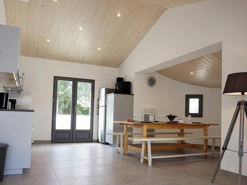 a kitchen with a wooden table and a refrigerator at Maison Noirmoutier-en-l&#39;Île, 4 pièces, 6 personnes - FR-1-224B-646 in Noirmoutier-en-l&#39;lle