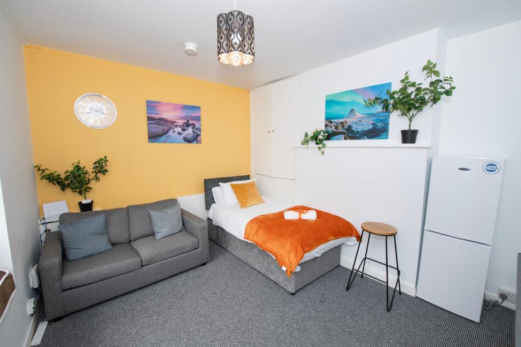 a bedroom with a bed and a couch at Versatile Cozy & Spacious Comfort Hull Apartments in Hull