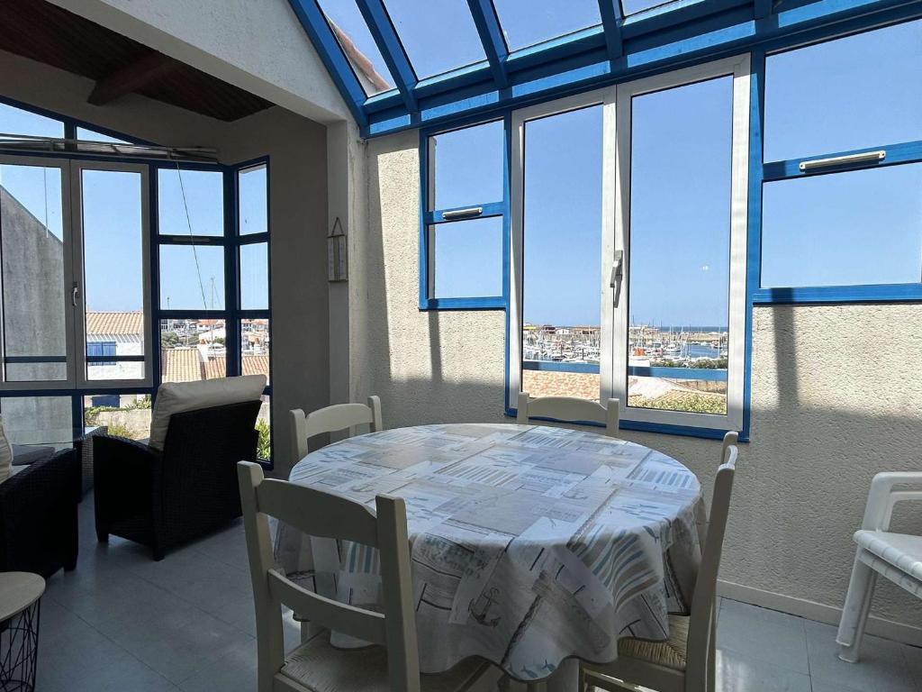 d'une salle à manger avec une table et quelques fenêtres. dans l'établissement Bel appart 3 pièces à L'Herbaudière, 2 chambres, plage à proximité - FR-1-224B-130, à LʼHerbaudière