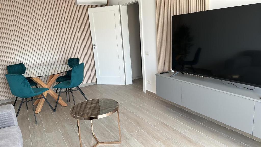 a living room with a table and chairs and a flat screen tv at Kronburg 95-12 in Braşov