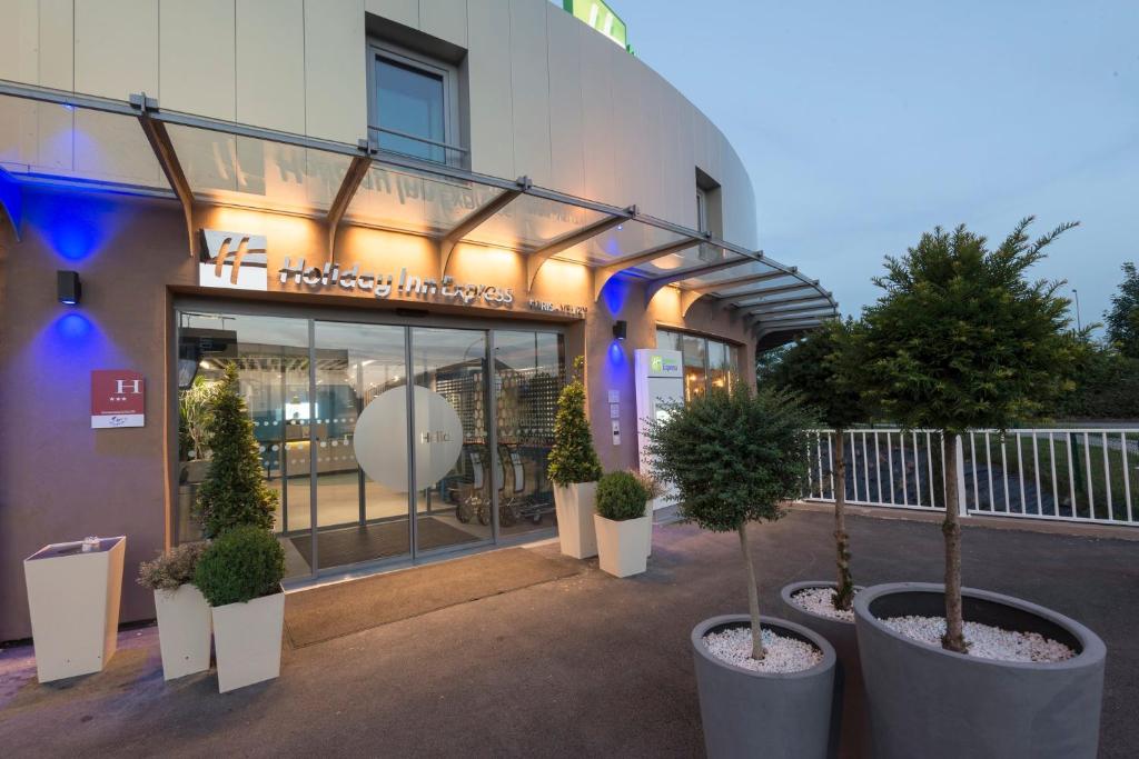 a building with potted trees in front of it at Holiday Inn Express Paris - Velizy by IHG in Vélizy-Villacoublay