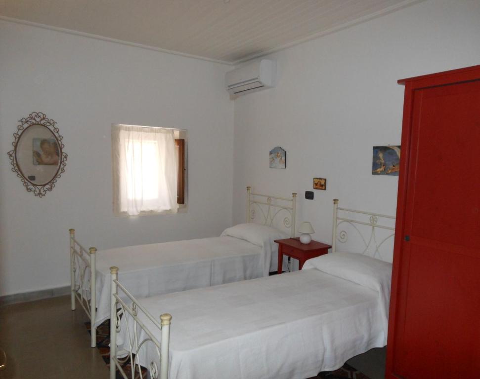 1 dormitorio con 3 camas y ventana en Mareluna, en Siracusa