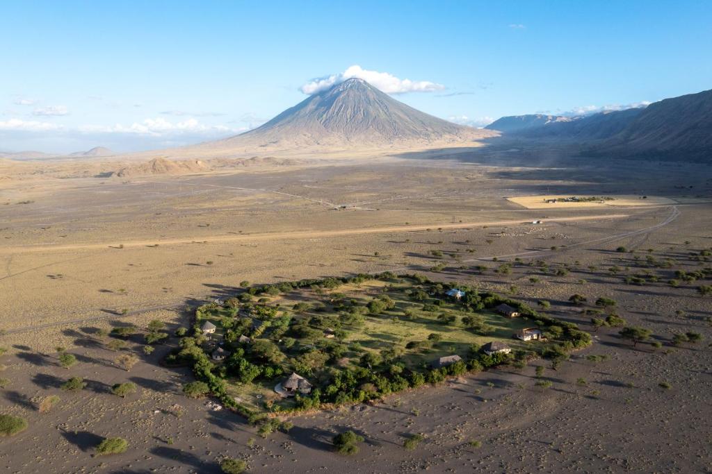 an island in the desert with a mountain in the background at Lake Natron Maasai giraffe eco Lodge and camping in Mtowabaga