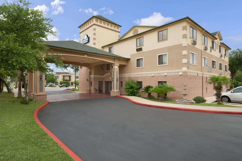 a parking lot in front of a building at Days Inn & Suites by Wyndham San Antonio North/Stone Oak in San Antonio