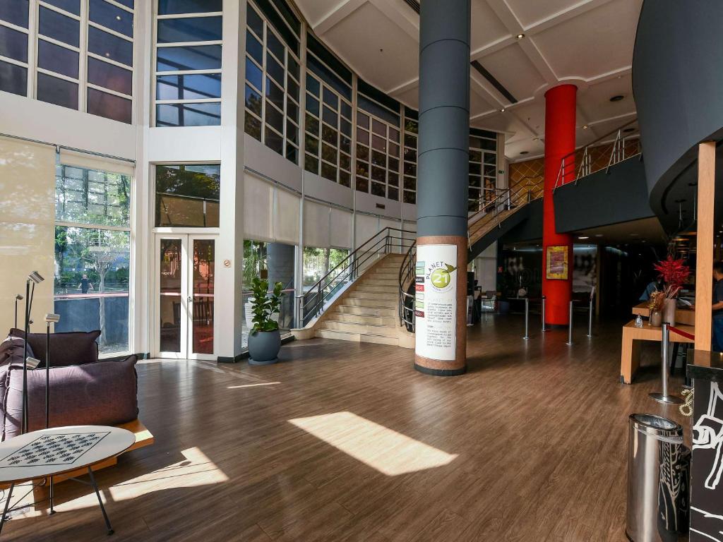 a lobby of a building with a large column at ibis Guarulhos Aeroporto in Guarulhos
