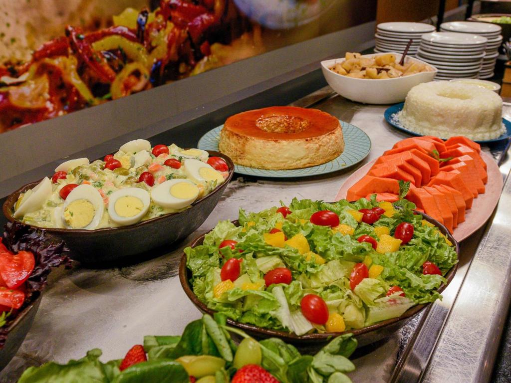 a buffet with different types of food on a table at ibis Guarulhos Aeroporto in Guarulhos