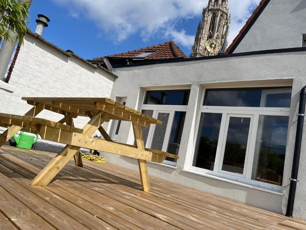 a wooden picnic table sitting on a wooden deck at Rooftop apartment with 60m terrace overlooking the cathedral in Antwerp