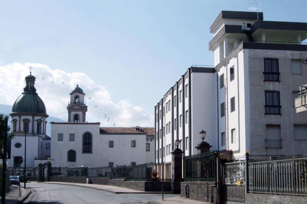 uma cidade com dois edifícios e uma torre de relógio em Hotel La Casa Del Pellegrino em SantʼAnastasia