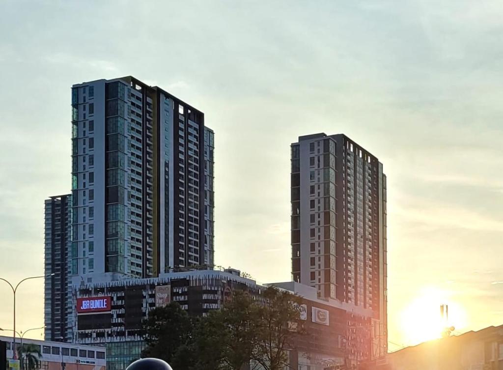 zwei hohe Gebäude in einer Stadt bei Sonnenuntergang in der Unterkunft Homestay FourSeasons @EVO MALL BANGI in Bandar Baru Bangi