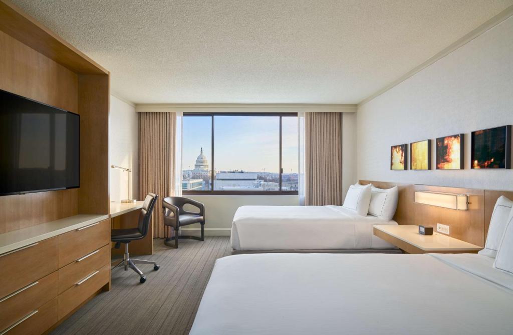 Hilton Washington DC Capitol Hill في واشنطن: غرفة فندقية بسريرين وتلفزيون بشاشة مسطحة
