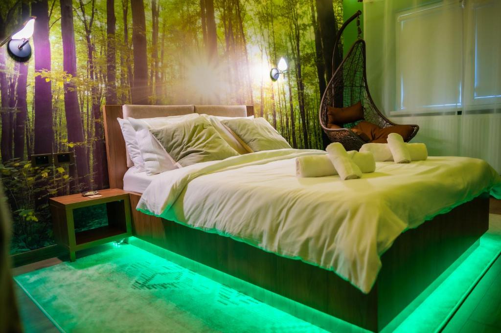 1 dormitorio con 1 cama grande y pared de bosque en Relaxveld Nature, en Curtea de Argeş